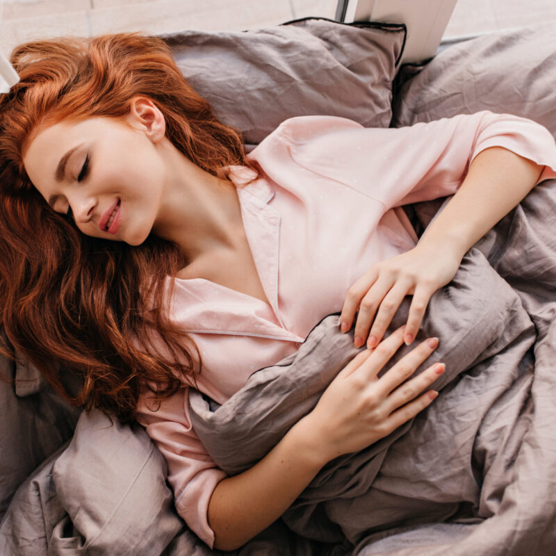 Appealing long-haired woman sleeping in morning. Inspired ginger girl lying in bed. Appealing long-haired woman sleeping in morning. Inspired ginger girl lying in bed.